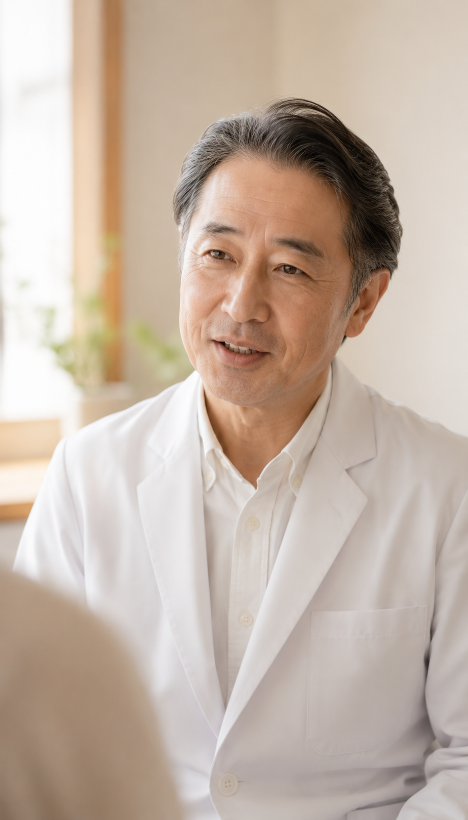 なごみ歯科医院 院長。患者さまと穏やかに対話する、柔らかな表情。